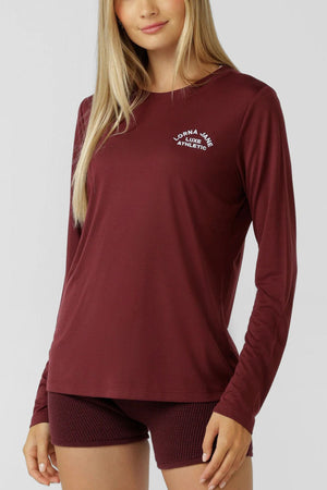 A person in the Lorna Jane Lotus Long Sleeve T-Shirt, crafted from lightweight breathable fabric and paired with matching textured activewear shorts, stands against a plain light background.