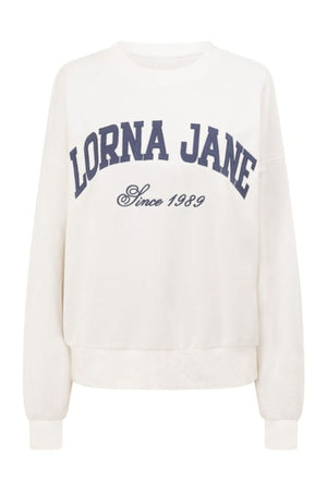 The Lorna Jane New Sport Sweatshirt is oversized and white, made from soft cotton terry with long sleeves. It features "LORNA JANE" in large navy blue letters and "Since 1989" in smaller script on the front.