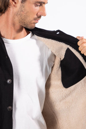 A man in a white t-shirt opens a Mr Simple Stockyard Sherpa Jacket, revealing its warm beige fleece lining and Regular Fit, set against a plain white background.