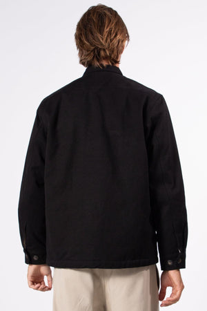 A person with light brown hair is shown from the back, wearing the Mr Simple Stockyard Sherpa Jacket in black and regular-fit beige pants against a plain, light background.