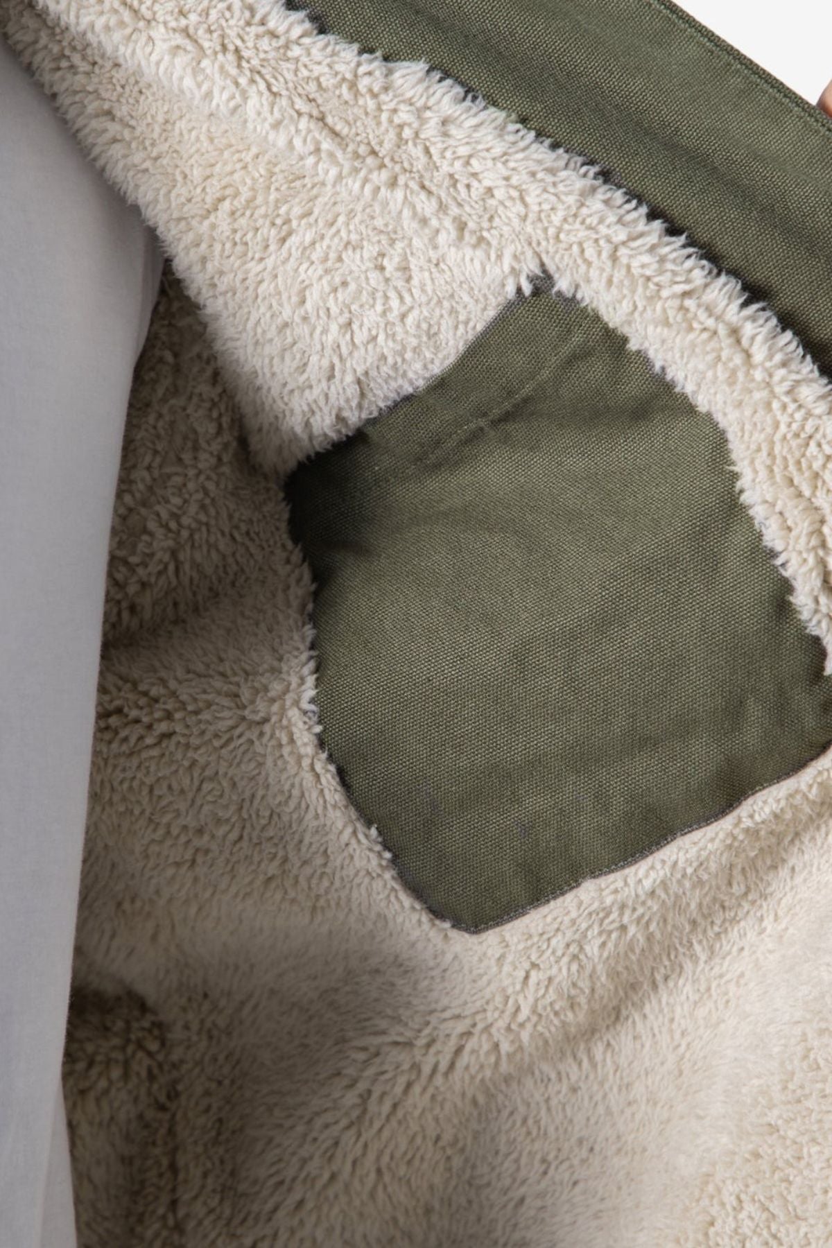 Close-up of the Mr Simple Stockyard Sherpa Jacket’s interior, featuring soft beige fleece lining and a green pocket. The fleece texture and stitching showcase the jacket’s regular fit craftsmanship.