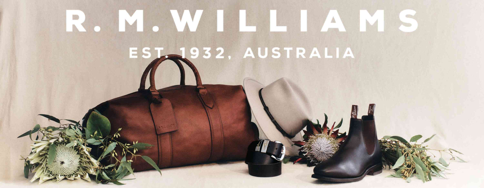 R.M.Williams Est. 1932, Australia. Leather duffle bag, Akubra hat, belt, boots & flowers pictured.