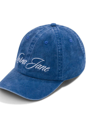 The Lorna Jane Heritage Washed Logo Cap features vintage blue denim and white embroidered "Lorna Jane" text on the front, shown angled against a white background.