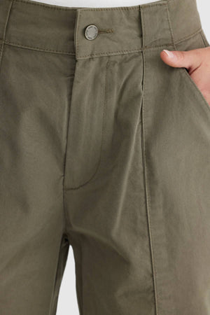 Close-up of a person wearing olive green ORTC Avery Front Seam Pants, with one hand in the pocket. These cotton tencel pants, designed in Australia, have a button closure and visible stitching details.
