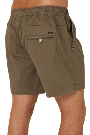 A person wearing Pilbara Cotton Stretch Shorts in olive green with an elastic waistband, embroidered logo, side pocket, and zippered back pocket, photographed from the back at thigh level.