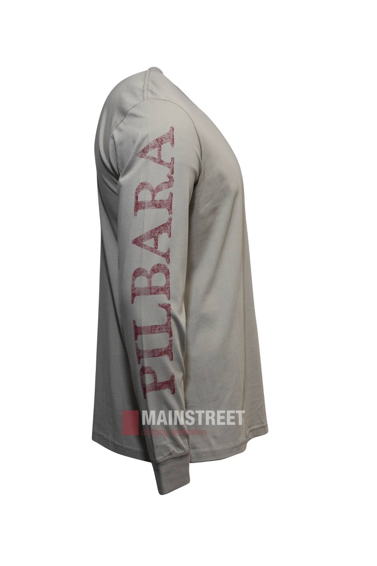 Side view of the Pilbara Long Sleeve T-Shirt, a beige 100% cotton shirt with "PILBARA" in faded red on the left sleeve and elasticised cuffs; features a plain design with no extra decorations.