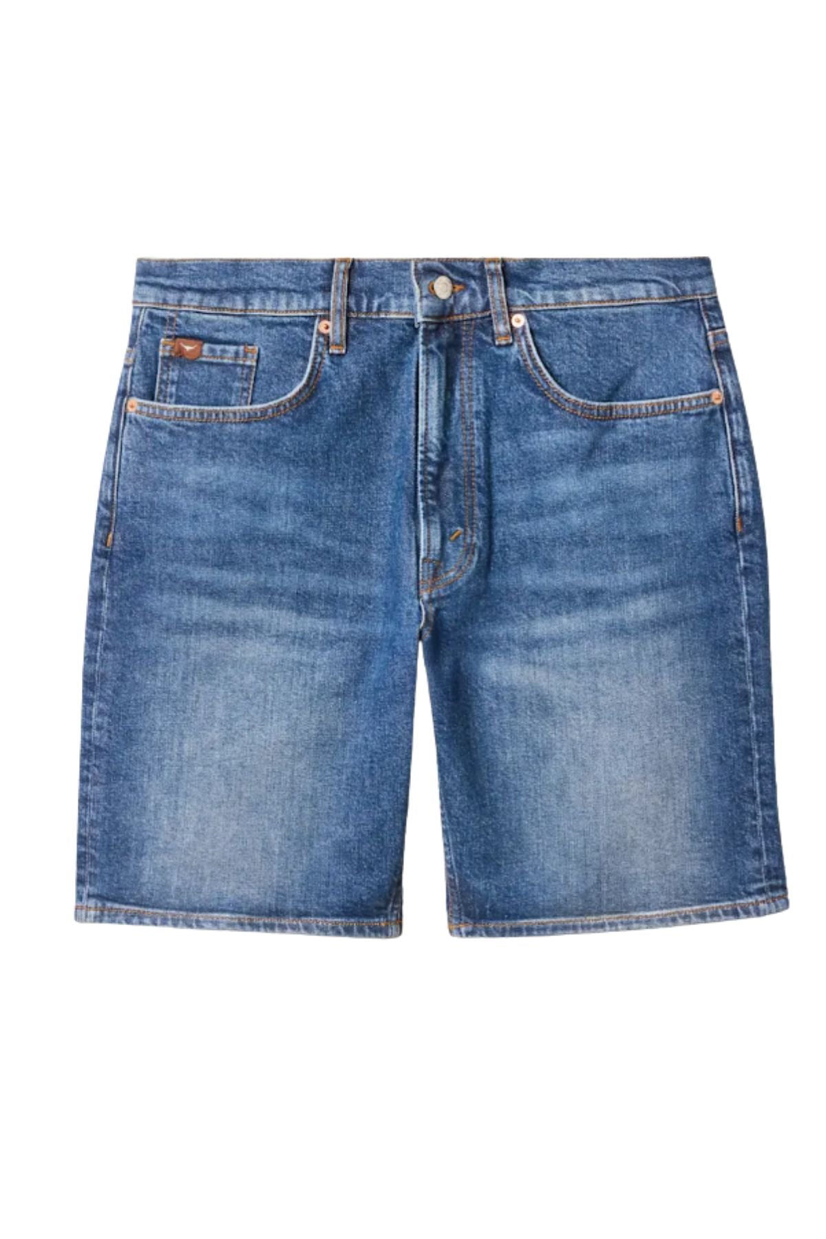 The RM Williams Nicholson Short in blue denim is crafted from Australian Good Earth Cotton, featuring a classic 5-pocket design with belt loops, a button fly, and a subtle faded finish. Shown on a white background with a slightly worn look.