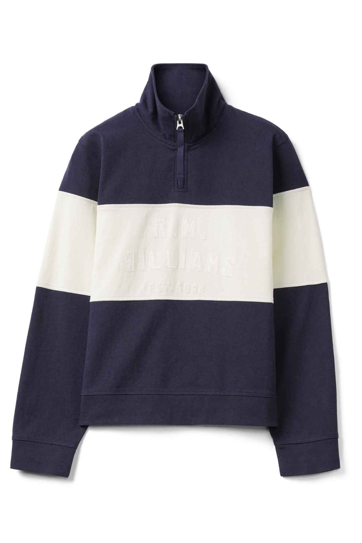 The RM Williams Trickett Panel Sweatshirt in navy blue features a high collar, front zipper, and two wide white stripes on the chest and sleeves. "R.M. Williams Est. 1932" is subtly embossed on the front and it's crafted from premium organic cotton for ultimate comfort.