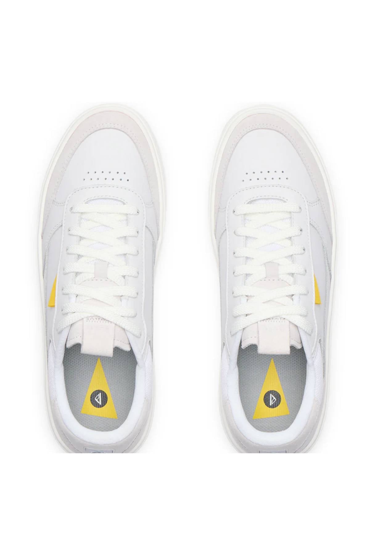 Top view of a pair of white Reef Bom Dia Shoes with cushioned footbeds for all-day comfort. The insoles display a yellow triangle with a black circular logo, and there’s a yellow accent on the outer sides.