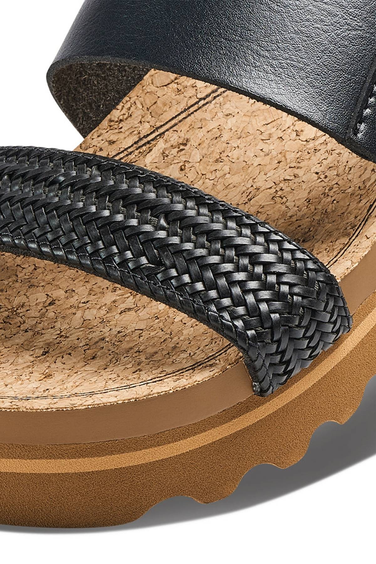 Close-up of the REEF Cushion Vista Hi sandal featuring a woven black strap, cork footbed, black leather upper, cushioned slides, thick tan sole with arch support, and a rugged, wavy tread pattern.
