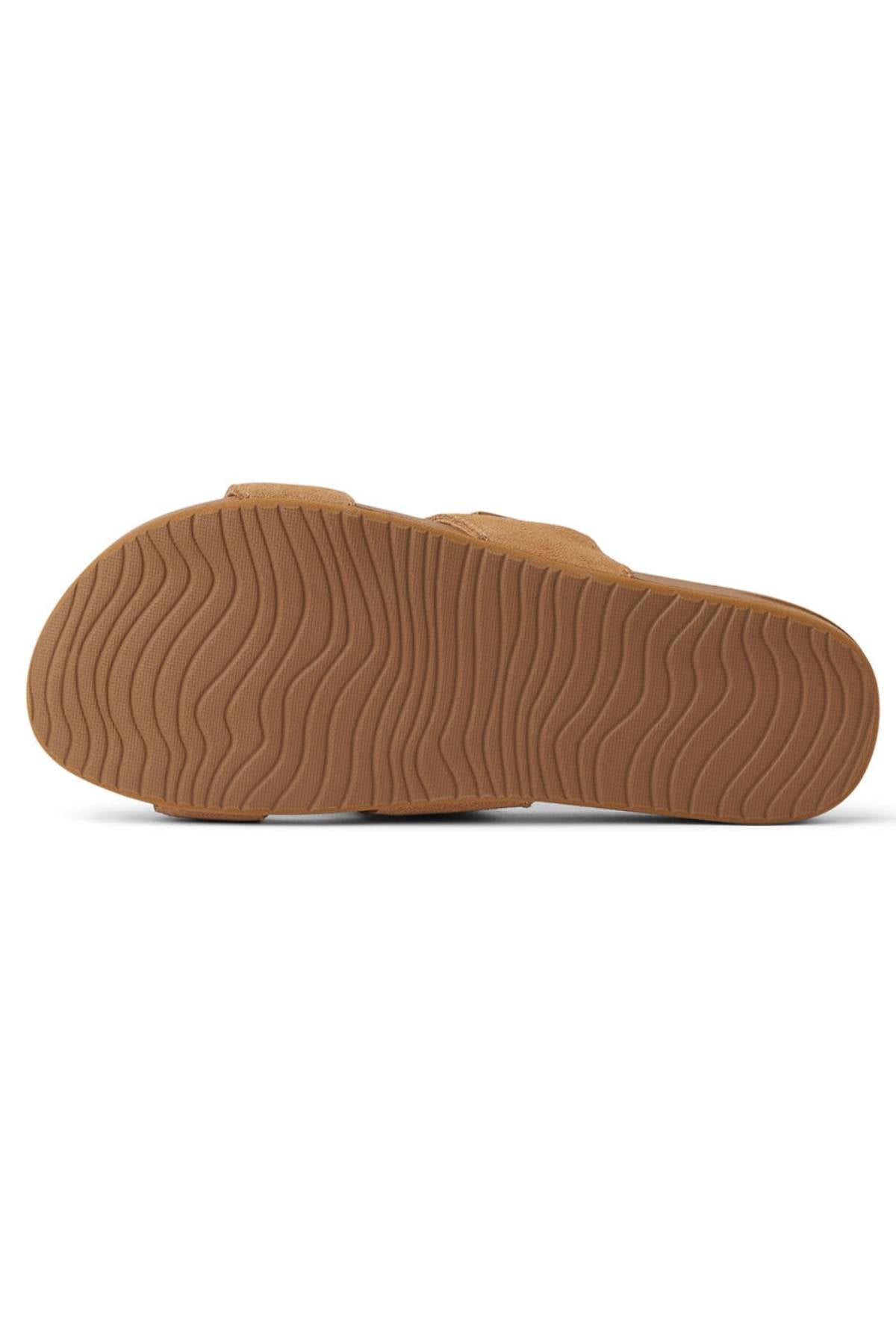 The REEF Cushion Vista Stevie is shown from the bottom, displaying its brown, textured wavy rubber sole and cushioned midsole for added comfort.