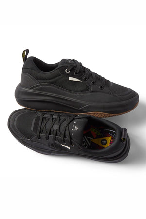The Reef Fanning Mens Shoe features black athletic sneakers with thick soles; one stands upright highlighting the side and sole, while the other lies on its side to reveal a multi-colored, cushioned insole for superior comfort.