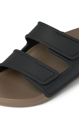 Close-up of the REEF Oasis Adapt sandal, featuring a brown EVA footbed and two wide black adjustable hook-and-loop straps. The simple, casual design makes it perfect for everyday wear.