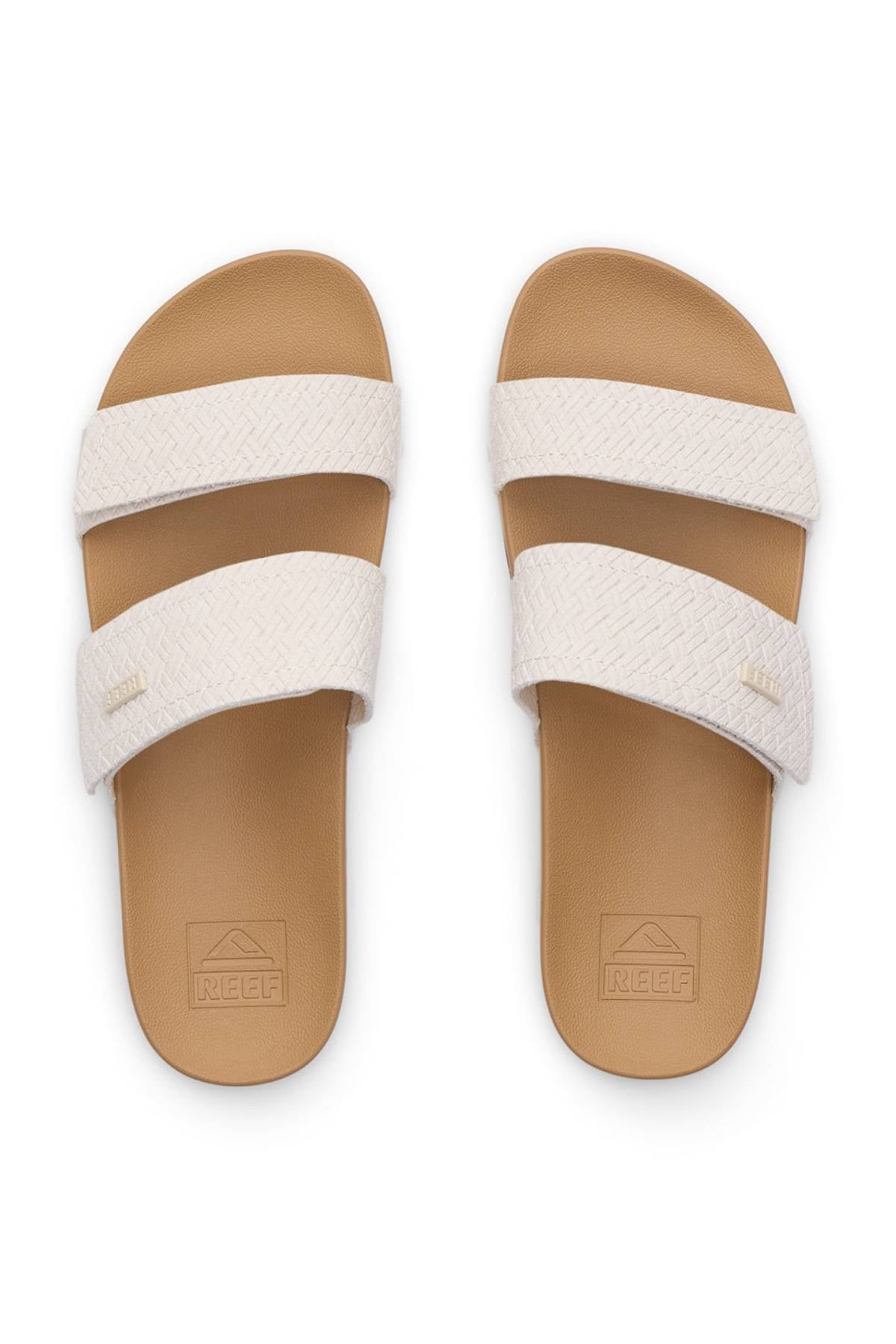 A pair of REEF Velcro Vista Se sandals in tan with textured off-white double straps, REEF branding on the footbeds, and a cushion midsole, shown from above on a white background.