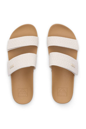 A pair of REEF Velcro Vista Se sandals in tan with textured off-white double straps, REEF branding on the footbeds, and a cushion midsole, shown from above on a white background.