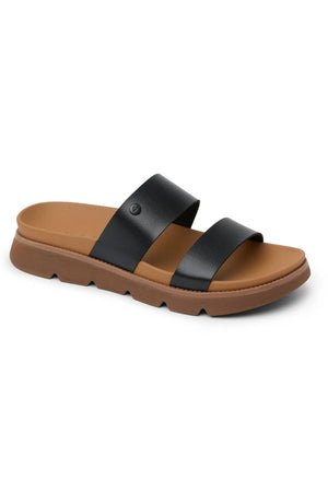The REEF Vista Luxe Thea is a black and brown slide sandal with two wide black vegan leather straps, a cushioned tan footbed, and a thick grooved brown sole for stylish comfort.