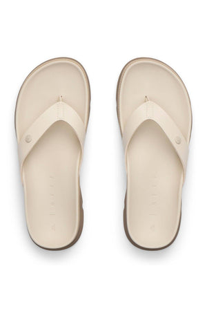 The REEF Vista Luxe Vivianahh is a pair of beige vegan leather sandals featuring wide straps and a cushioned footbed, shown from above on a white background.