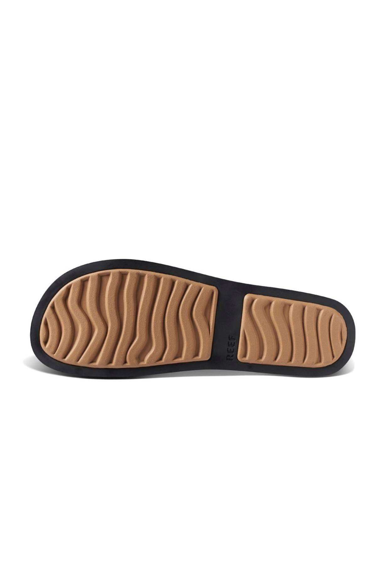 The REEF Water Vista Slide sandal features a black-bordered, textured tan sole. It's waterproof with wavy grooves for traction and a dual-density EVA footbed for comfort. "REEF" is embossed near the edge.