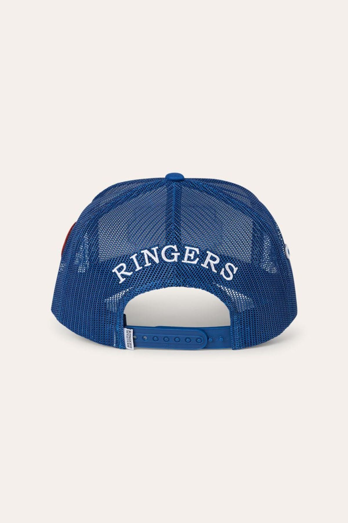 The Ringers Western Drive By Deep Fit Trucker Cap is a blue mesh trucker hat shown from the back, showcasing white embroidered “RINGERS” text above its adjustable snap closure. This deep fit design ensures all-day comfort and sun protection.