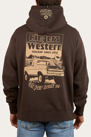 Wearing the Ringers Western Get Your Truck On Pullover Hoodie, made from premium brushed fleece, with a vintage pickup truck graphic and "Ringers Western Truckin’ Since 2012" plus "Get your truck on" text on the back, and a small logo on the hood.