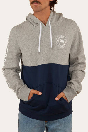Someone wears the Ringers Western Hahndorf Hoodie in gray and navy, a relaxed fit with brushed fleece, white drawstring, front pocket, and printed chest and sleeve text, styled with light blue jeans.