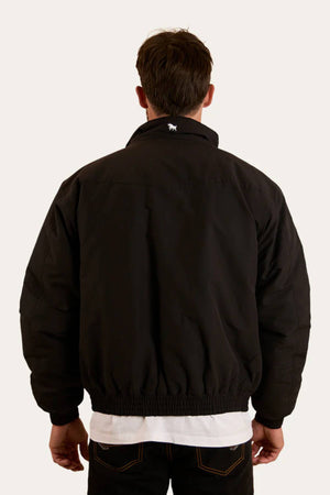 A man faces away from the camera wearing a black Ringers Western Kidman Jacket with a white shirt and dark jeans. The jacket features quilted lining and a small white animal logo on the upper back, set against a plain light background.