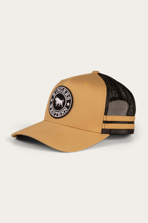 The Ringers Western McCoy Trucker Cap is a tan and black cap with a curved brim and mesh back. The front showcases a circular patch bearing the words "Ringers Western" and an image of a bull. The mesh section features two black stripes running horizontally, and it comes with an adjustable strap to ensure the perfect fit.