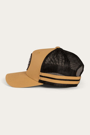 Side view of a tan Ringers Western McCoy Trucker Cap with a black mesh back. The cap features two horizontal tan stripes on the mesh and a round patch on the front panel. An adjustable strap ensures the perfect fit. The brim is slightly curved. The background is a plain, light color.