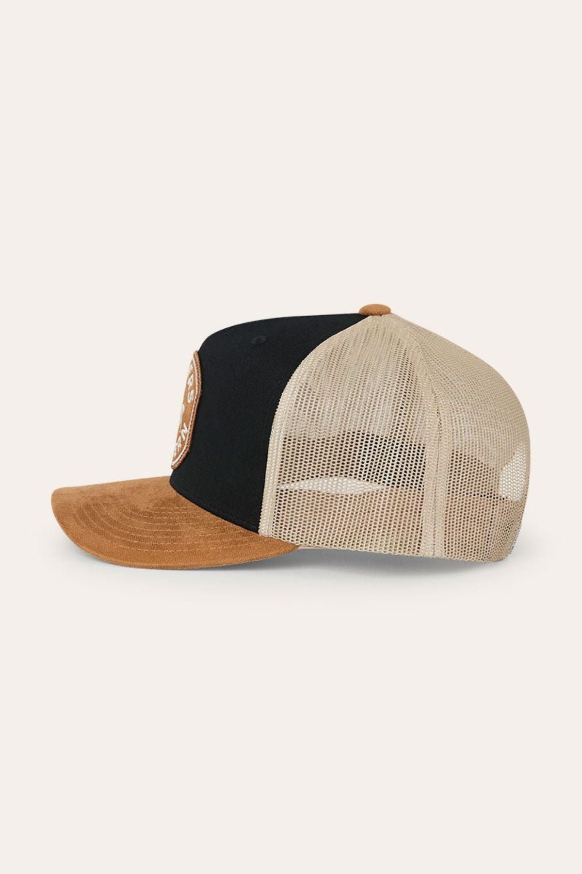 Introducing the Ringers Western Outback Hide Roadhouse Trucker Cap—a stylish two-tone trucker hat crafted with a black front panel, tan suede-like brim, and beige mesh back. Featuring a round brown patch on the front panel, this western-inspired cap offers an adjustable snapback closure for a comfortable and custom fit.
