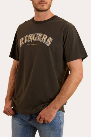 A man wearing the Ringers Western Princeton Loose Fit T-Shirt in dark brown, made from 100% cotton jersey with bold "RINGERS" puff ink print on the chest, and blue jeans stands relaxed against a plain background.
