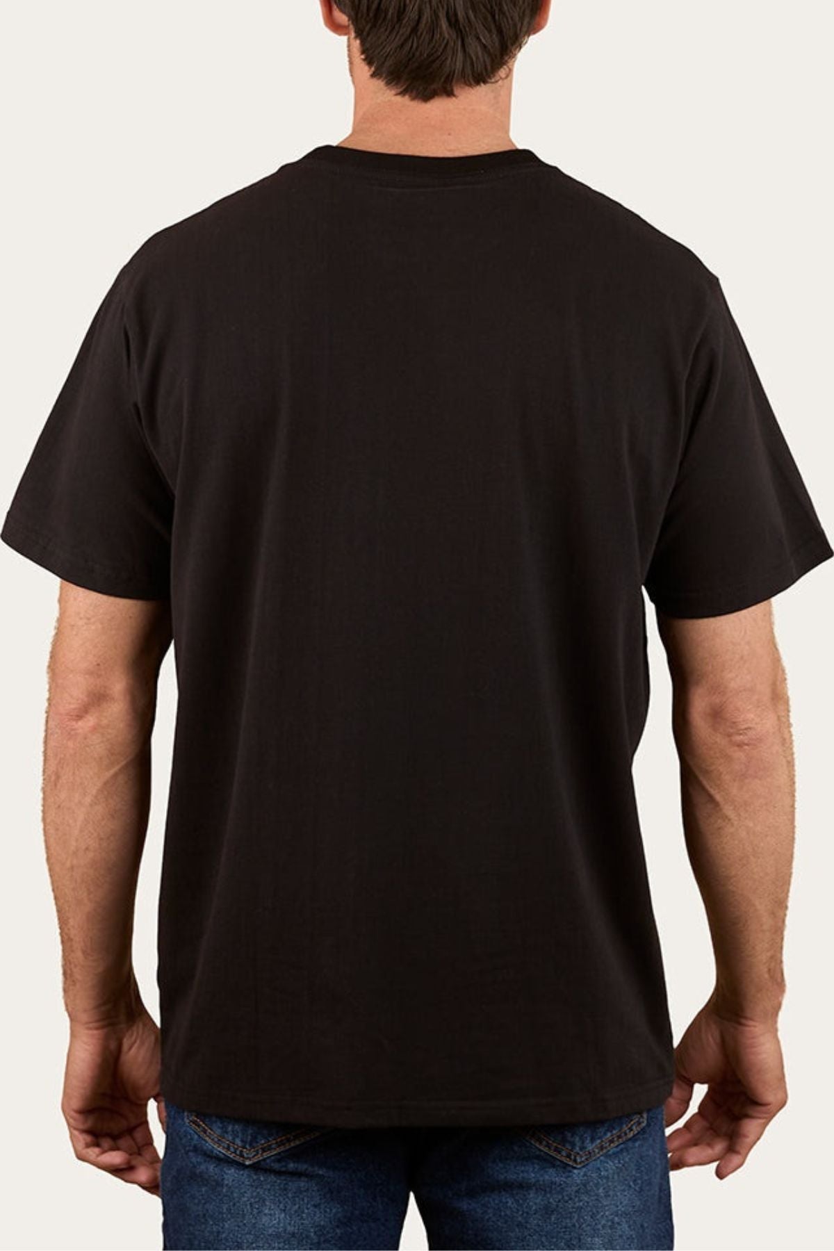 A person wearing a Ringers Western Princeton Loose Fit T-Shirt in plain black, made from 100% cotton, and blue jeans, shown from the back against a light background.