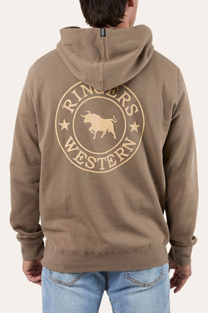 Wearing the Ringers Western Signature Bull Pullover Hoodie with a bold circular logo and bull graphic on the back, paired with light blue jeans. The cozy fleece hoodie is showcased as the person faces away from the camera.