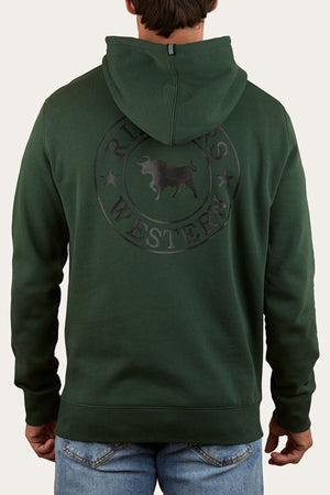 A person wearing a dark green Ringers Western Signature Bull Pullover Hoodie with a circular bull and stars logo on the back, paired with blue jeans. The individual, facing away from the camera, showcases "Ringers Western" on the hoodie.