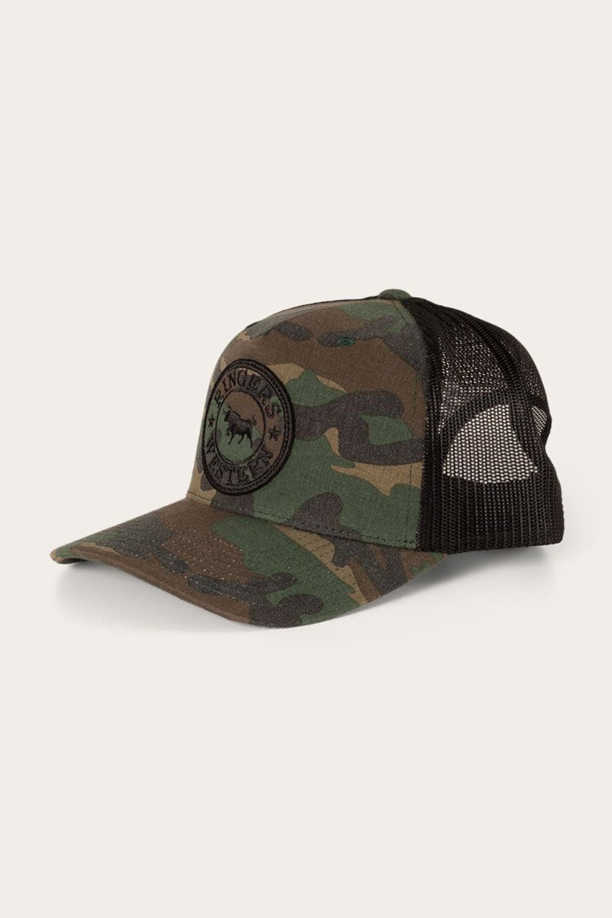 The Ringers Western Signature Bull Trucker Cap showcases a green and brown camouflage cotton twill front with a black mesh back, an adjustable snapback closure, and a circular black patch featuring the brand’s signature bull and “KING’S VINTAGE” text.
