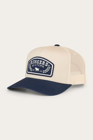 Introducing the Ringers Western Wheatbelt Trucker Cap: this beige and navy mid-profile trucker hat features a curved bill and breathable mesh back. A front patch displays “Ringers Western” with laurel leaves and a small cattle graphic. Complete with an adjustable snapback closure for a custom fit.