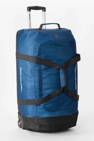 The Rip Curl Jupiter Search Ref 80L Travel Bag is a large blue, water-resistant duffel with wheels, a retractable handle, black straps, and "AIR EQUAL" on the side, standing upright against a plain white background.