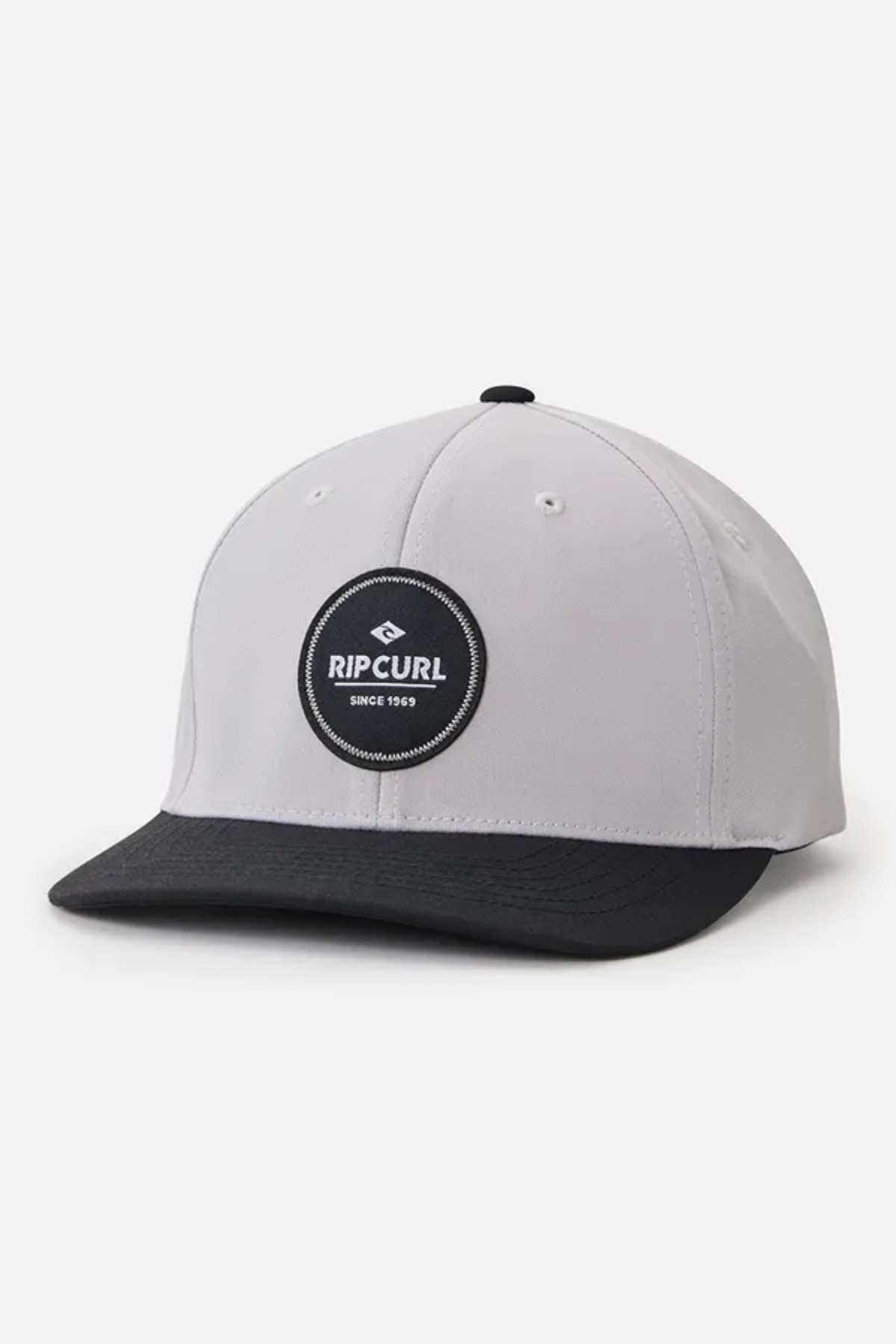 The Rip Curl Routine Flexfit Trucker is a baseball cap that features a gray crown with a black brim and a round black patch on the front. The patch displays the Rip Curl logo along with the text "Since 1969." Ideal for outdoor enthusiasts, this cap is set against a plain white background.