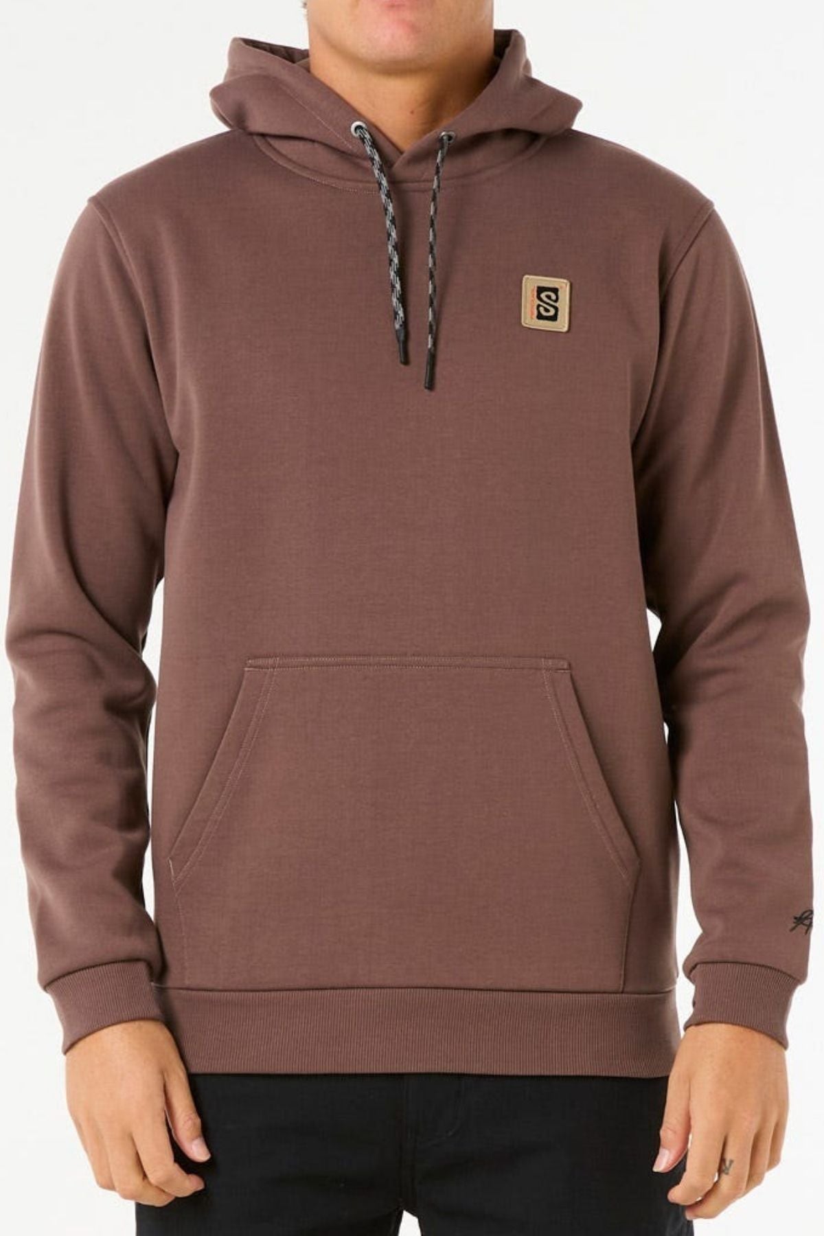 A person wears the Rip Curl Anti Series Search Base Hood—a brown hooded sweatshirt with a front pocket, small square chest logo, bonded polar fleece for warmth, black and white drawstrings, and a standard fit. Their hands rest at their sides.