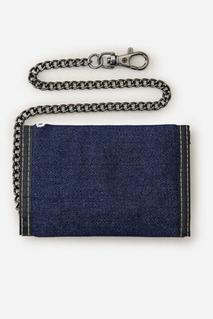 The Rip Curl Archive Denim Surf Wallet, made from blue cotton denim with black trim, features a chunky black metal chain and clasp, displayed against a plain white background.