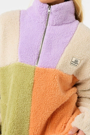 Wearing the Rip Curl Block Party Polar Fleece, which features a zipper, high collar, and pastel purple, cream, green, and orange panels with a chest patch logo for a unique look.