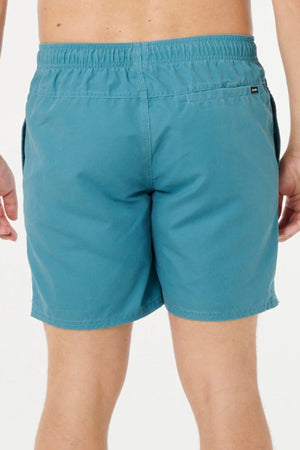 A person is shown from the waist down, wearing teal Rip Curl Bondi Volley swim shorts made from recycled PET. The shorts feature an elastic waistband and a small back right pocket. The background is plain white.
