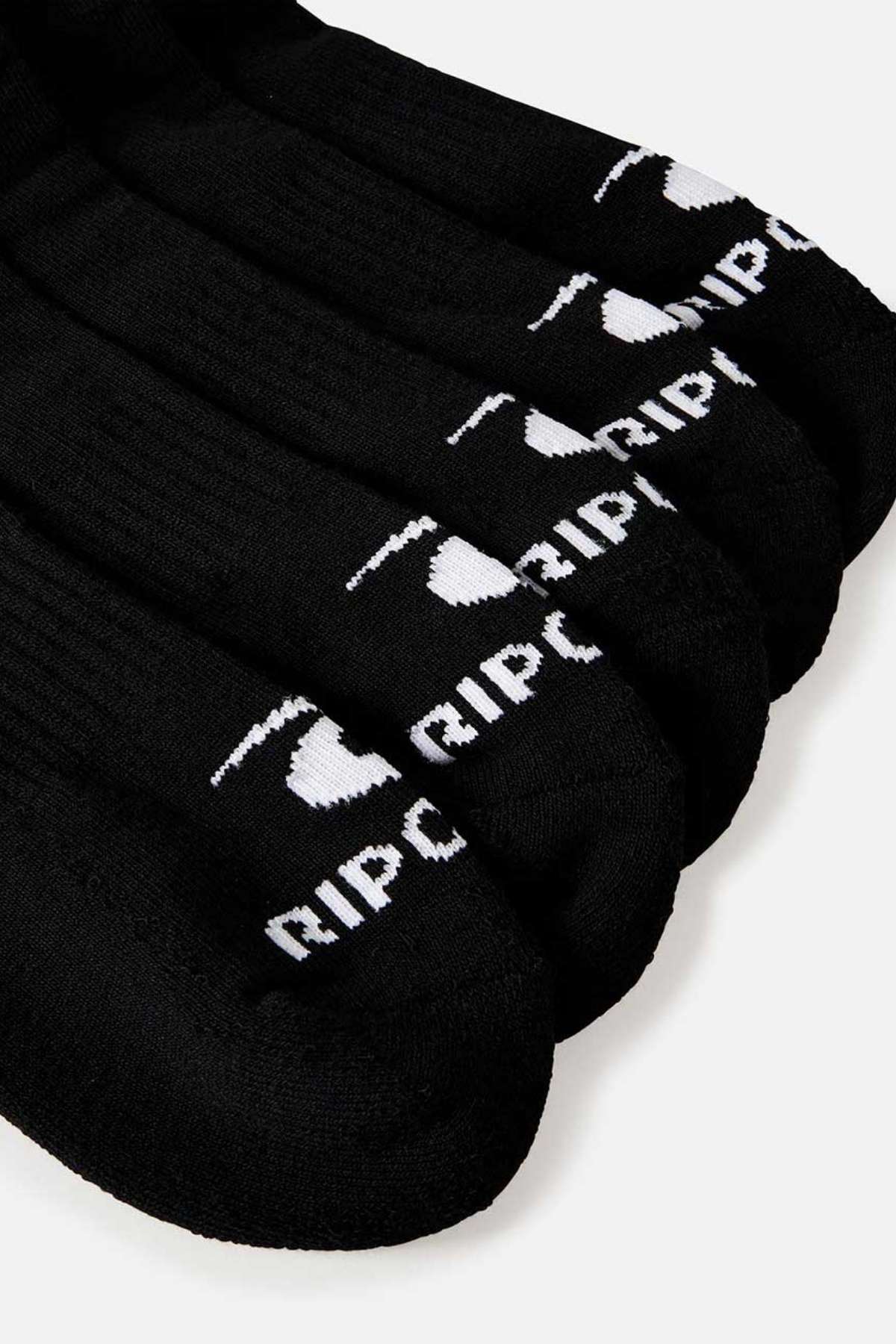Close-up of Rip Curl Brand black ankle socks with white lettering and a logo near the toes, featuring arch support, arranged in a neat row.