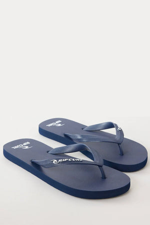 A pair of Rip Curl Brand Logo Bloom Thongs in blue, featuring white "Rip Curl" logos on the straps and footbeds, made from eco-friendly algae-blended foam, displayed on a plain white surface.