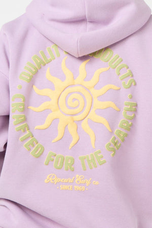 The Rip Curl Cala Heritage Hood, in a heritage fit, features a yellow spiral sun and text "QUALITY PRODUCTS CRAFTED FOR THE SEARCH" and "Ripcurl Surf co. SINCE 1969" on lavender organic cotton-poly fleece.