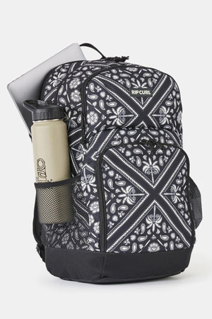 Black and white patterned Rip Curl Chaser 33L Backpack with a water bottle in the side mesh pocket.