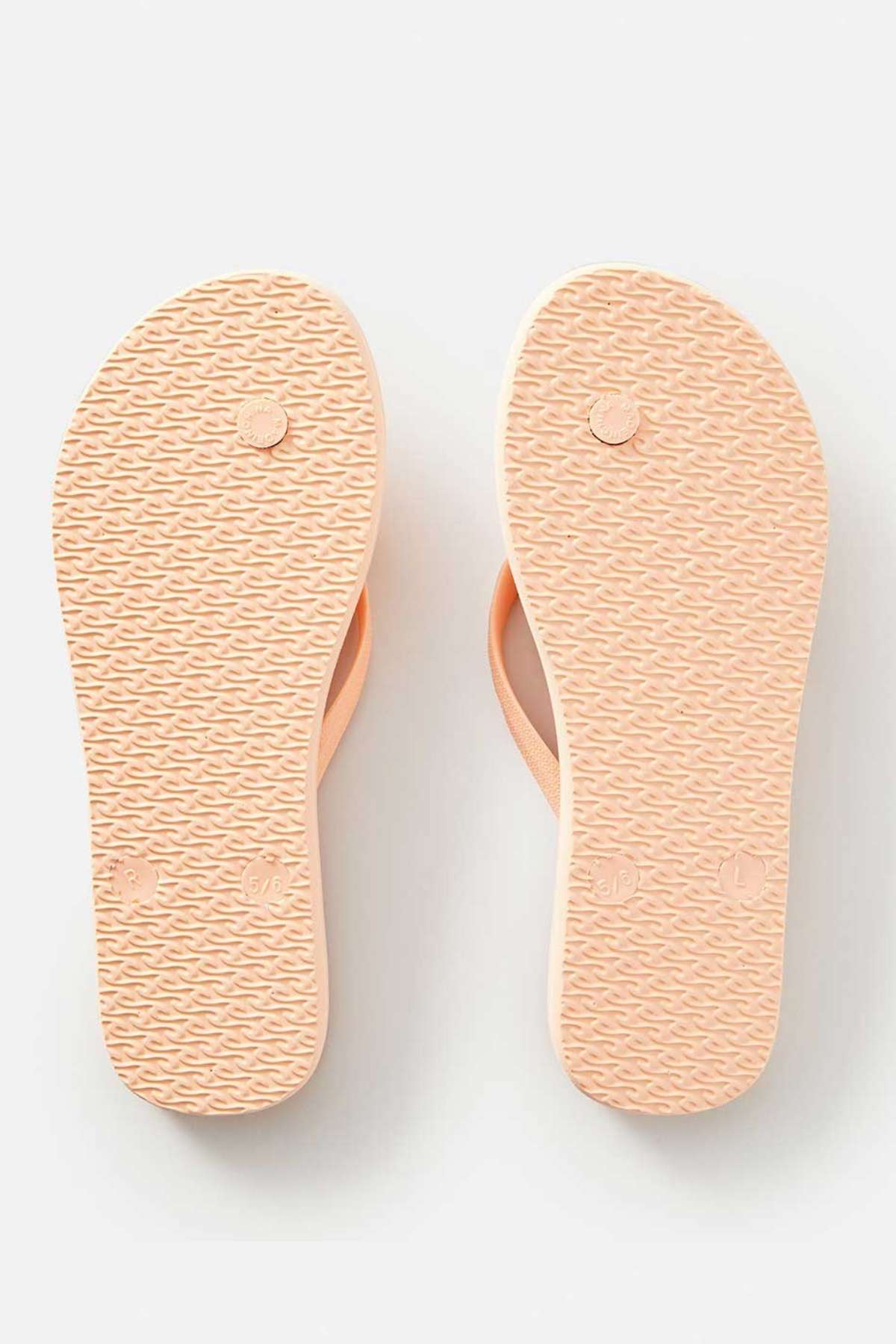 A pair of Rip Curl Classic Surf Bloom Thongs in light pink, featuring textured soles made from sustainable BLOOM™ algae-blended foam EVA, displayed from the bottom. The thongs are positioned side by side on a plain white background.