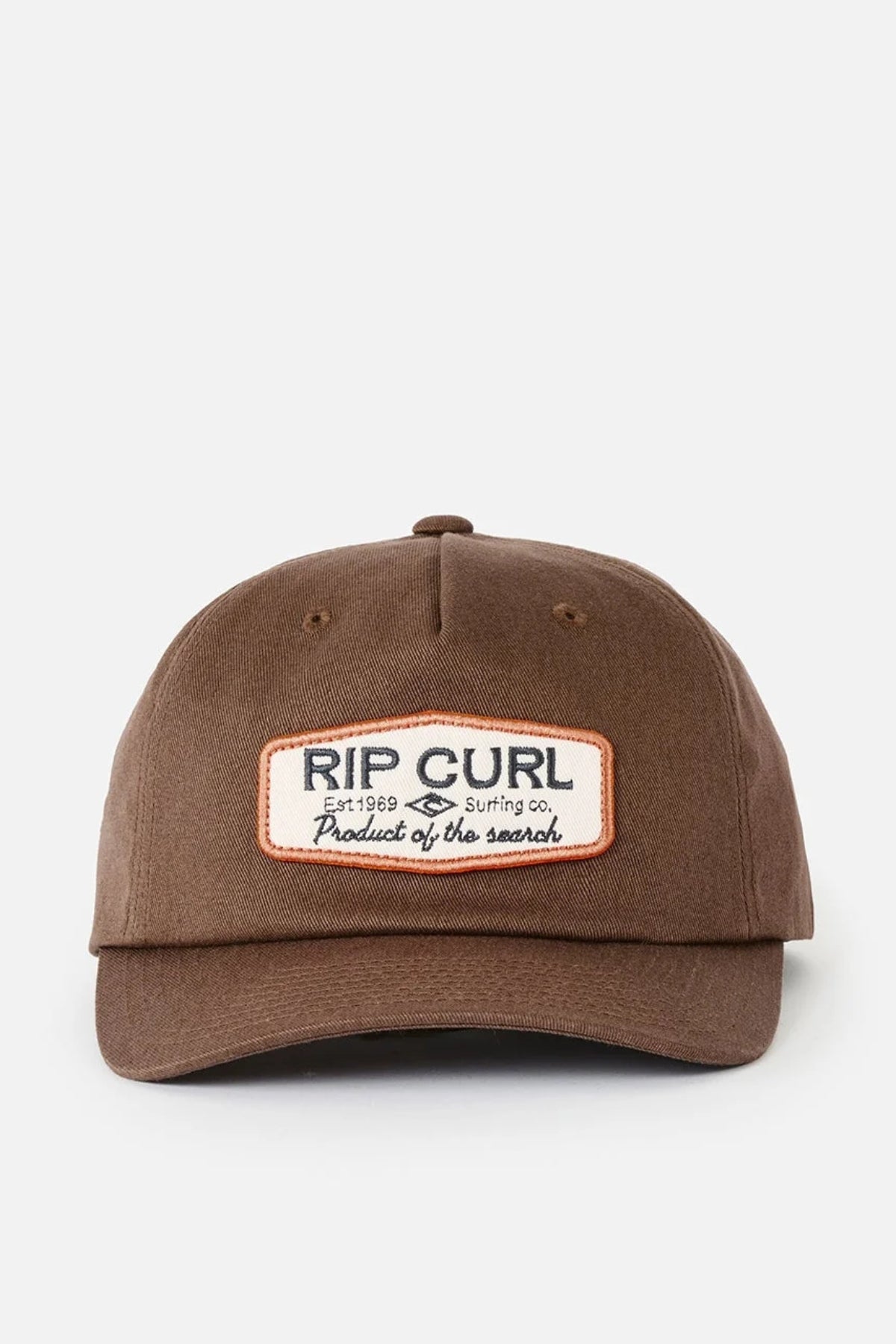 Introducing the Rip Curl Classic Surf SB Cap—a brown cotton snapback hat featuring a rectangular front patch that reads “RIP CURL Surfing Co. Product of the search.” The cap is showcased against a plain, light background.