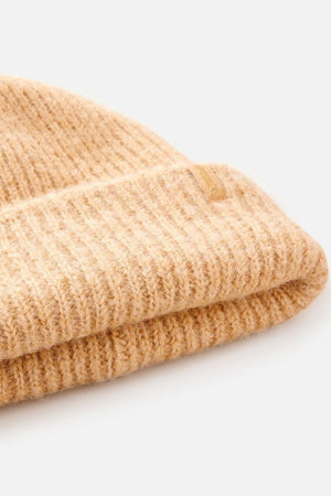 A close-up of a beige Rip Curl Classic Surf Tall Beanie with a folded brim, displayed on a white background. This knit hat delivers warmth and style for the season.