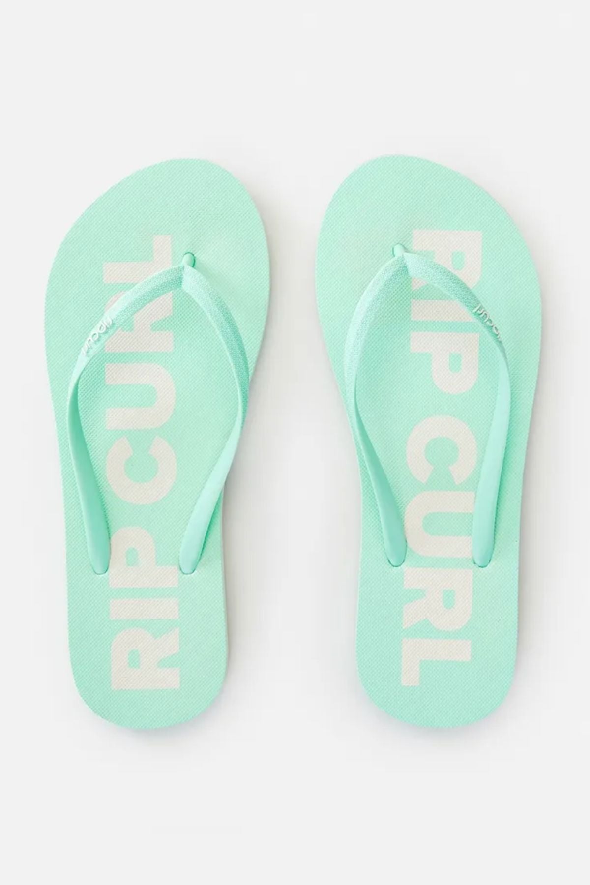 A pair of Rip Curl Classic Surf Thongs in mint green, featuring "Rip Curl" printed in white on the rubber footbed, with matching mint green straps against a light gray background.