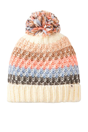 The Rip Curl Cosy Regular Pom Pom Beanie features a knit design with a pom-pom top, horizontal stripes in cream, peach, brown, blue, and gray, and a thick cream-colored folded brim for added warmth.